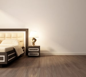 dark brown laminate flooring in a bedroom with a bed