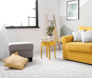 gray patterned carpet in a living room with a yellow couch