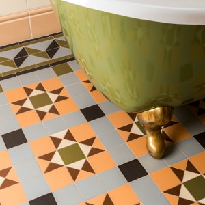 patterned multi-color tile flooring in a bathroom with a green tub